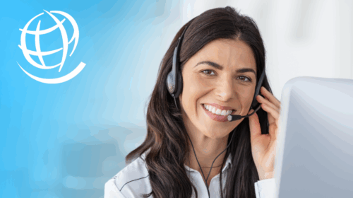 A woman smiles as she talks on the phone through a head set.