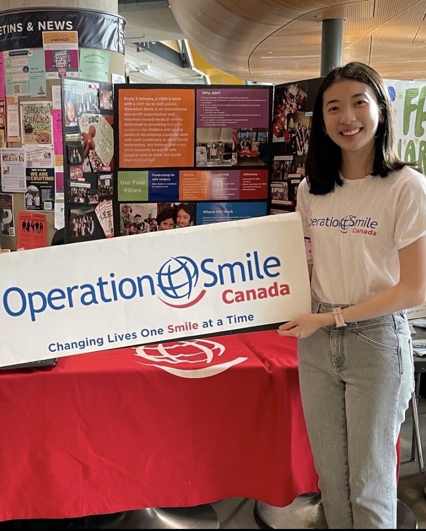 Female student volunteer holding an Operation Smile Canada banner