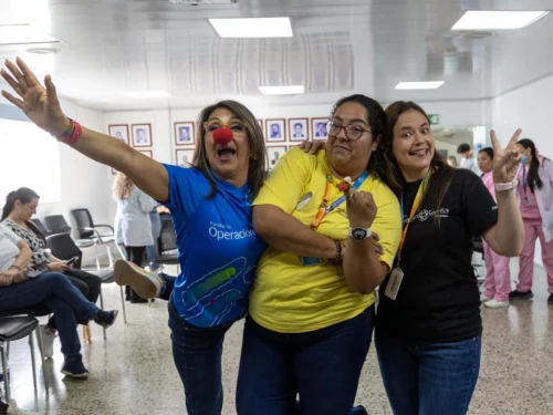 Three female volunteers at a surgical program in Colombia, one wearing a red clown nose.