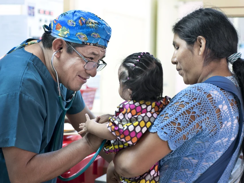Medical volunteer interacts with a patient during comprehensive health evaluations.