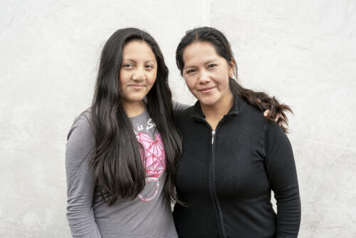 Girl stands with her mother