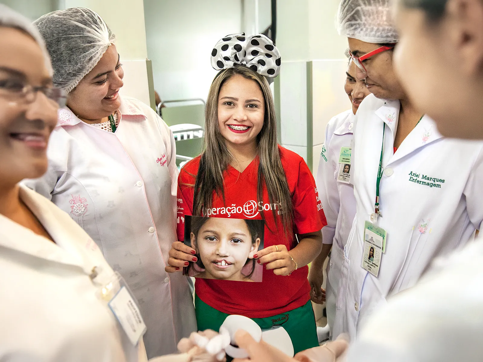 Antonia Sales (19 years old) holding her before surgery picture surrounded by hospital employees