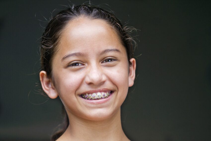 A young girl smiles with braces.