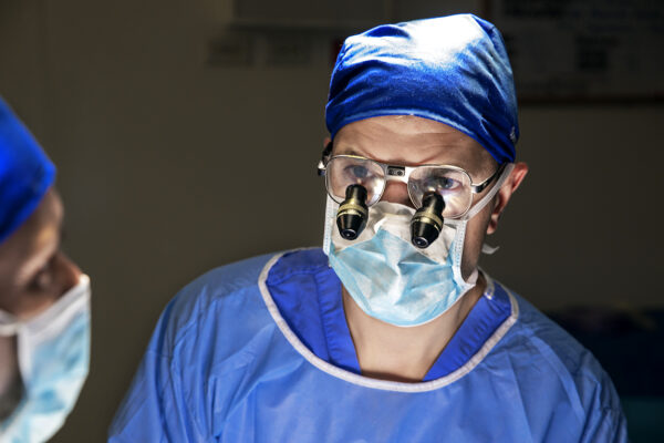 Surgeon wearing eyepieces to perform a cleft surgery