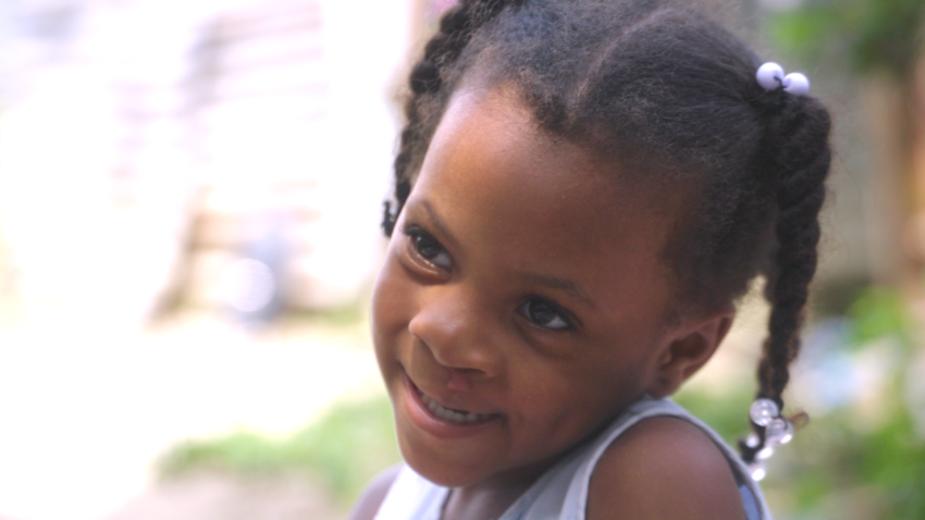 Young girl is shy but smiling.