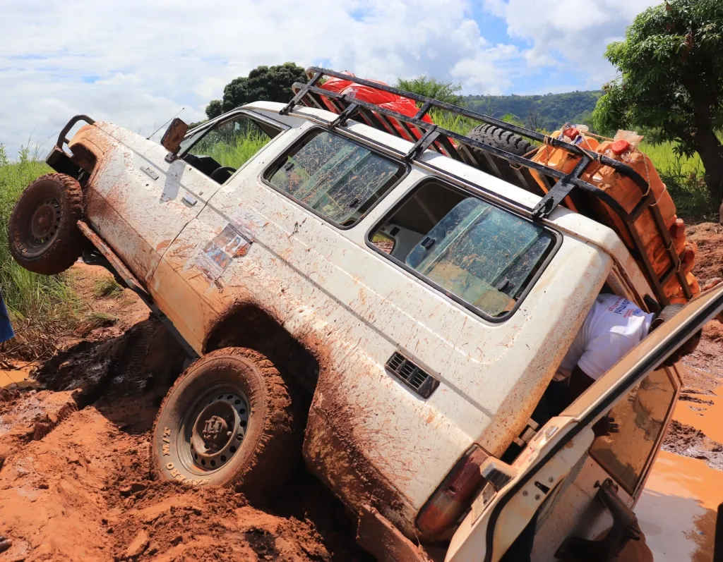 A truck is tipped on its side in orange mud