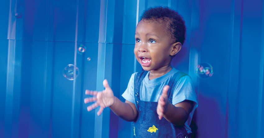 Young boy excitedly plays with bubbles.