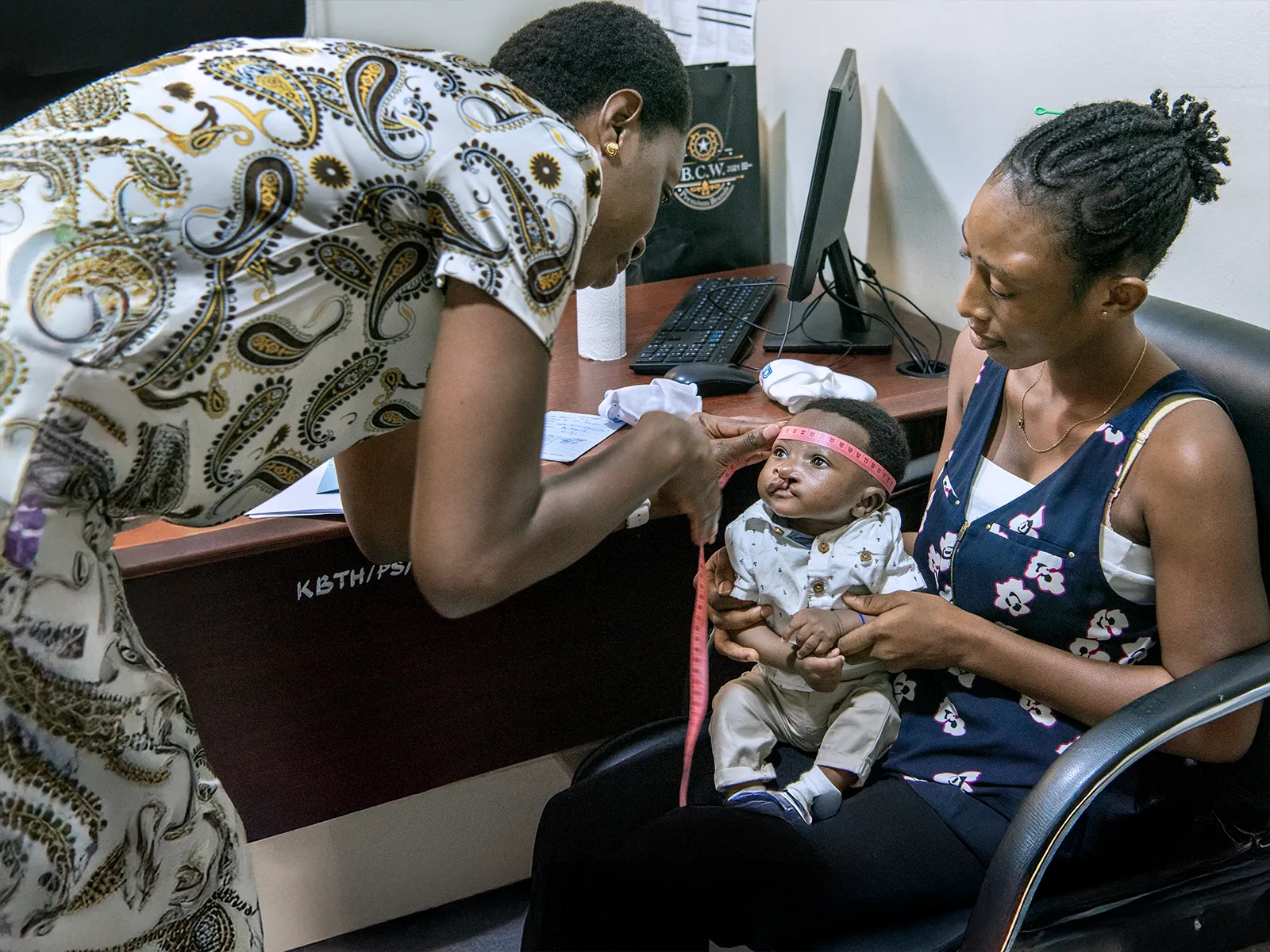 Nutritionist, Georgina Ntem of Ghana, measuring the circumference of the head.