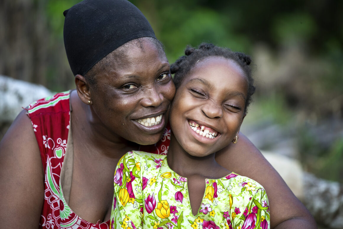 A mother and daughter smile proudly.