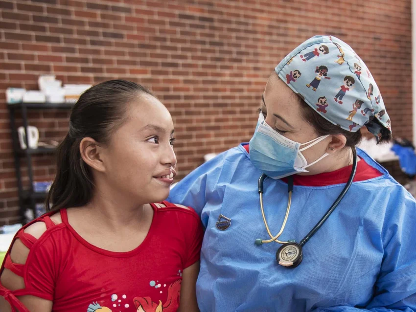 A female teenage patient with a medical volunteer preparing for surgery