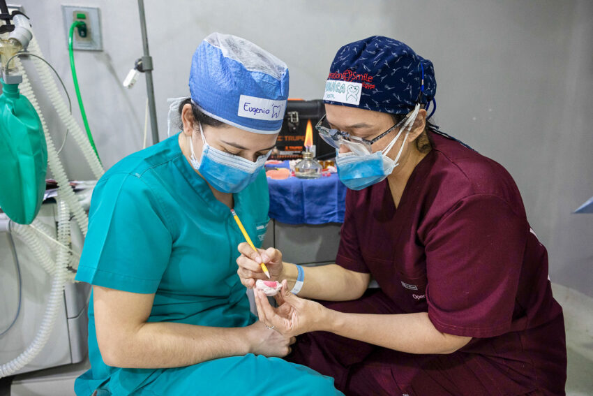 A couple of women wearing scrubs and face masks