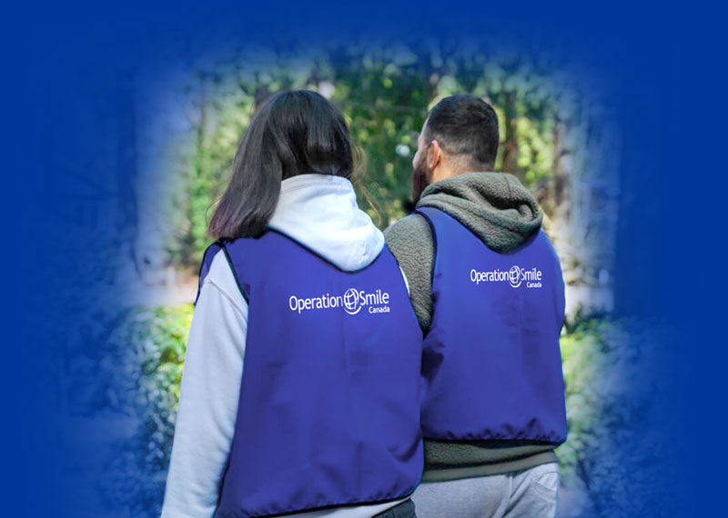 A man and a women with Operation Smile branded vests