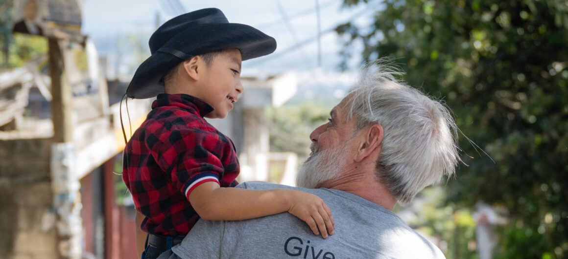 Man holding child wearing a cowboy hat