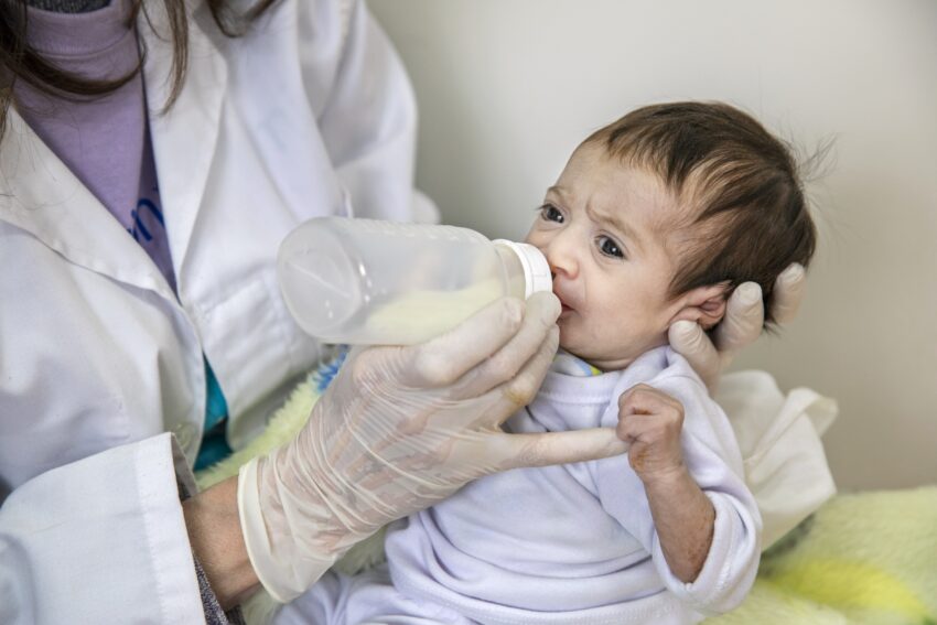 A baby feeds from a bottle.