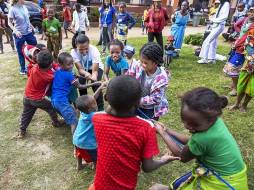 Children are playing a game while waiting for their health evaluations at a surgical program in Madagascar.
