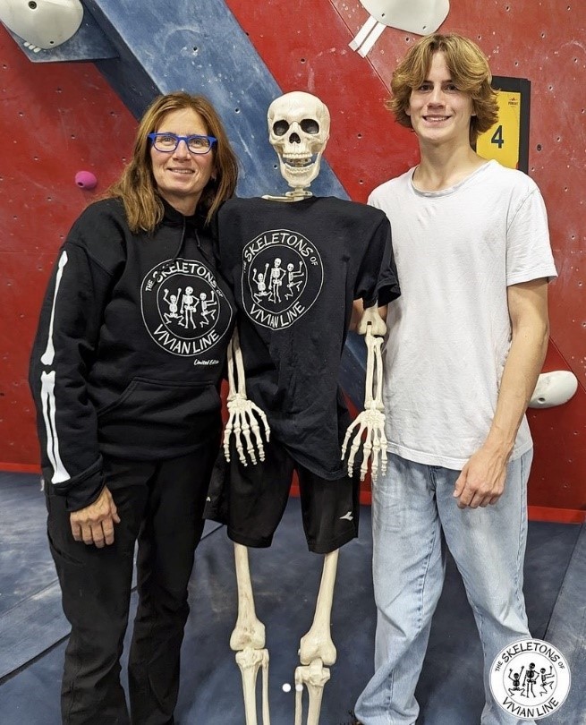 Woman and teenage boy standing on either side of a skeleton they use in their display called Skeletons of Vivian Line