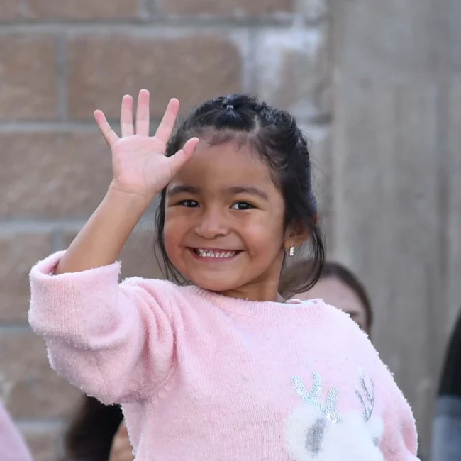 Lilia from Mexico waves at the camera as she smiles proudly.