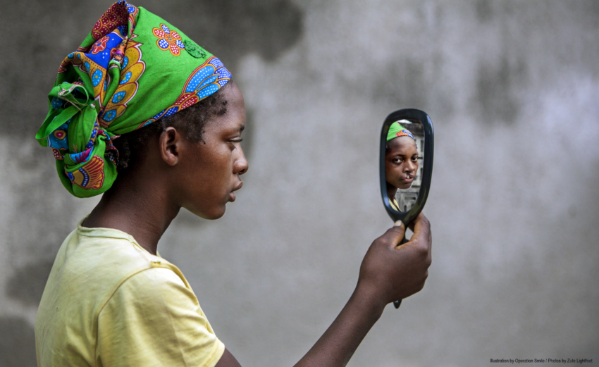 21 year old female looks at her smile in a mirror