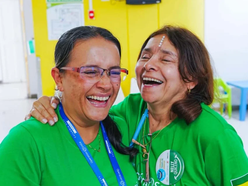 Two female volunteers are seen laughing and having fun.