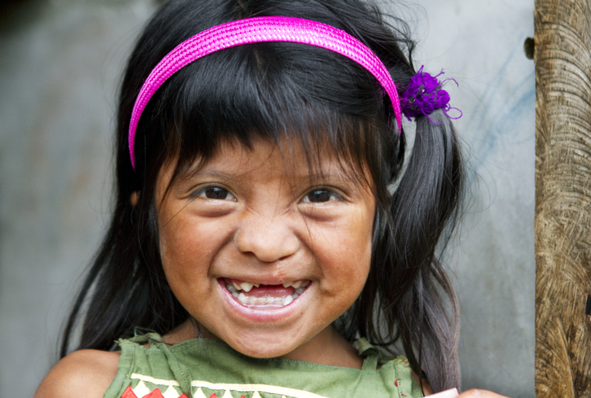 Young girl smiling with pink headband on