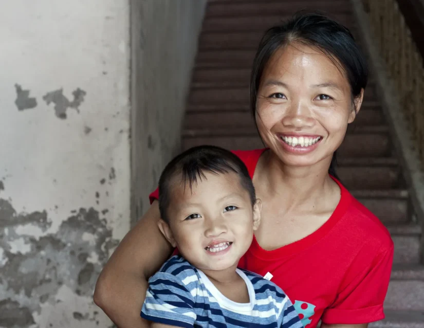 Danh smiles in his mother Ai’s arms after his cleft surgery, both looking joyful and full of gratitude.